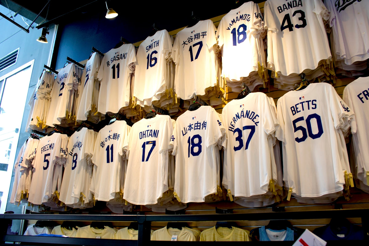 White baseball jerseys with numbers displayed on wall