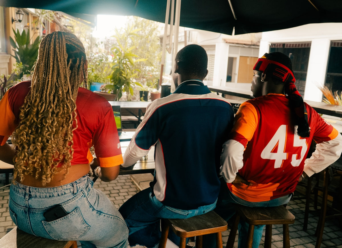 Three friends sitting at a bar looking out